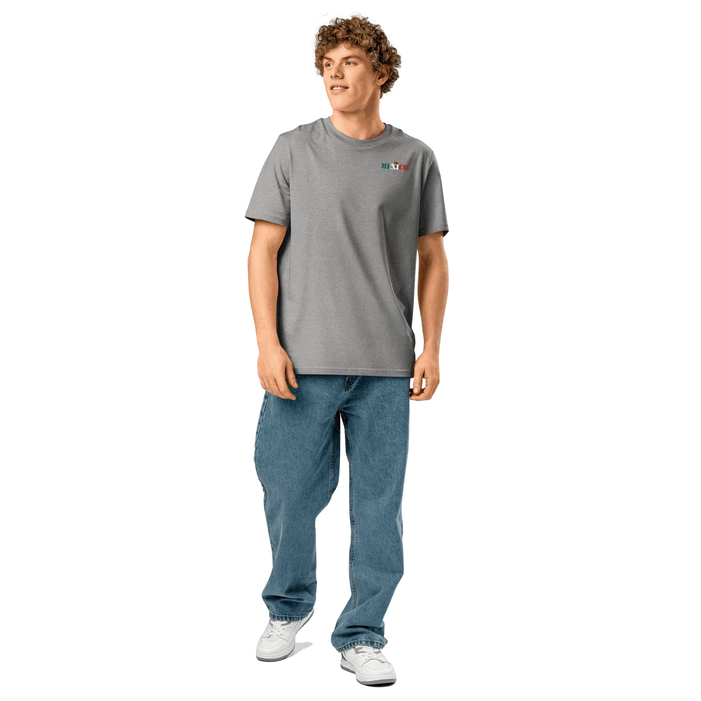 Man wearing a gray Mexico Futbol Shirt with flag-inspired text and blue jeans standing against a white background